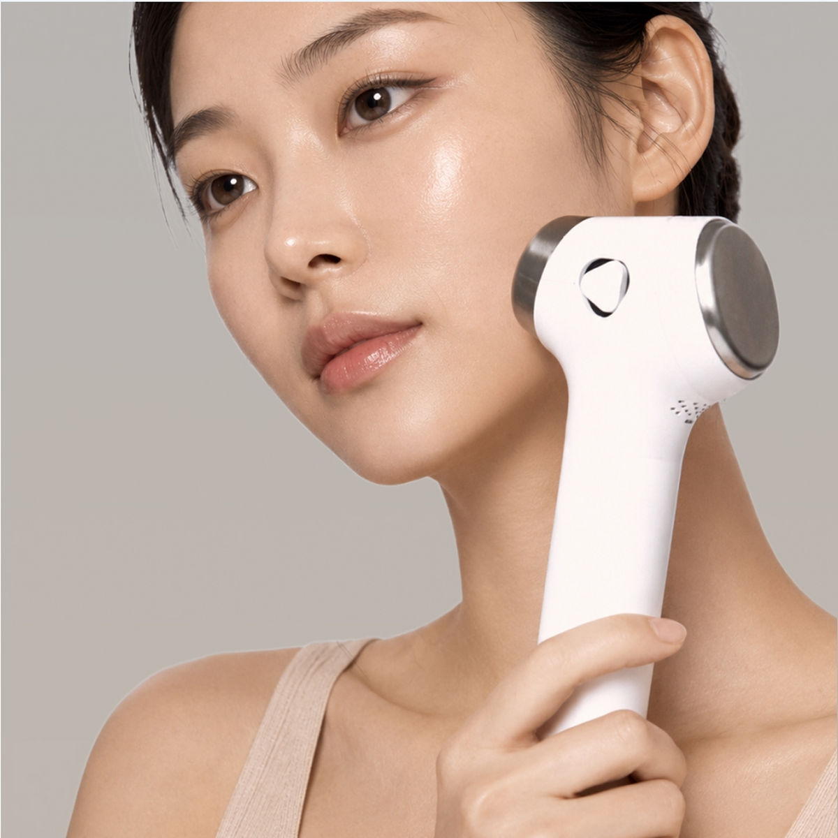 Woman using the glow.m Cryo Sonic Pro on her cheek